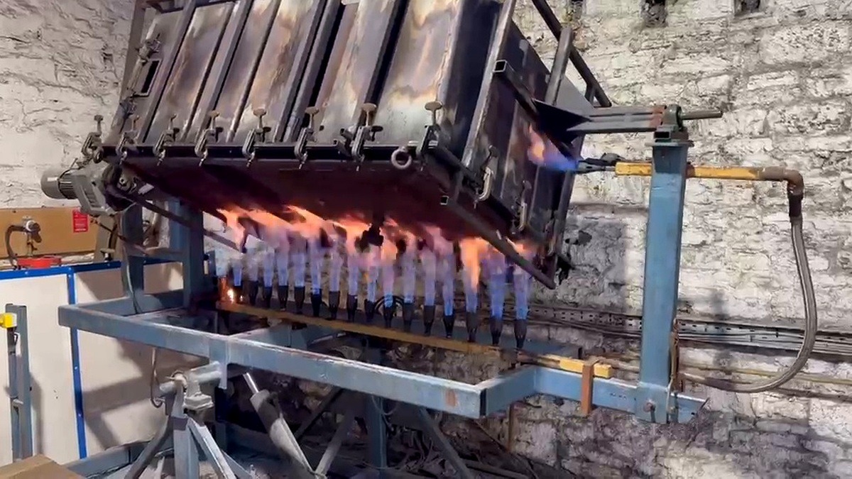Rotational moulding machine during a heating cycle with hydraulic mould movement